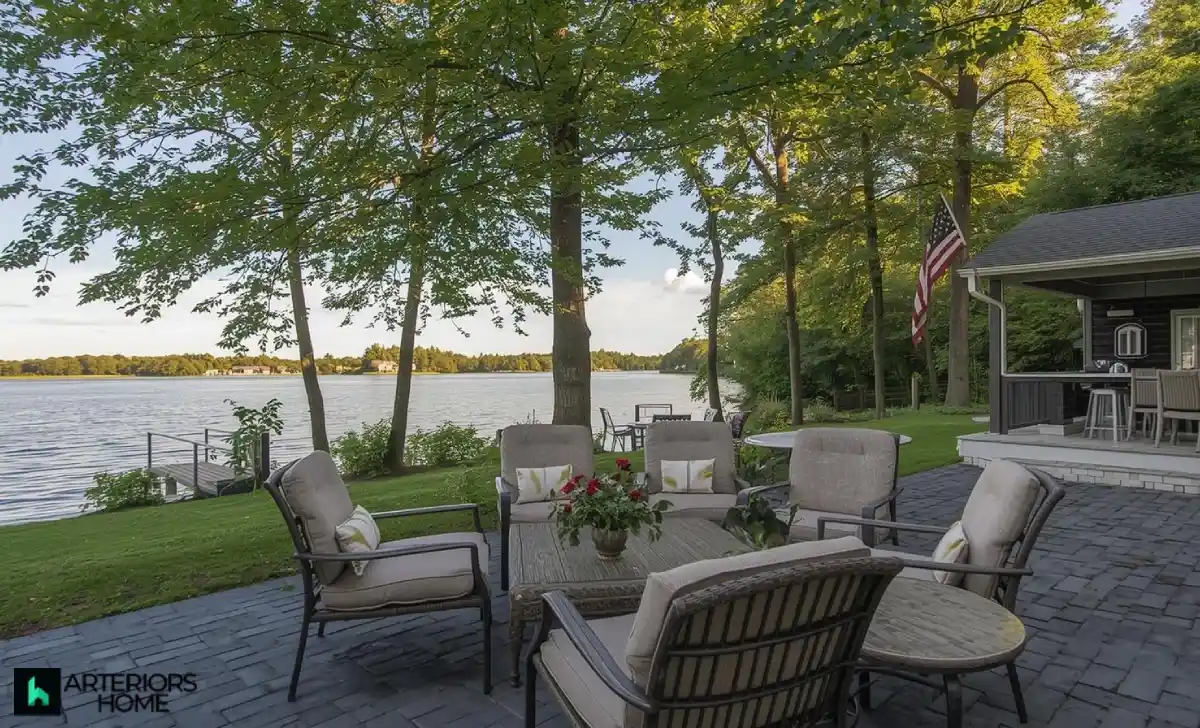 Luxurious lakefront backyard with pool, greenery, and café table during sunset at the Wakile estate.
