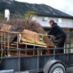 Worker loading junk onto a trailer as part of a hauling service