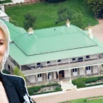 Aerial view of Nicole Kidman House, showcasing the grand Australian farmhouse with a green roof, wraparound verandas, and lush landscaped grounds.