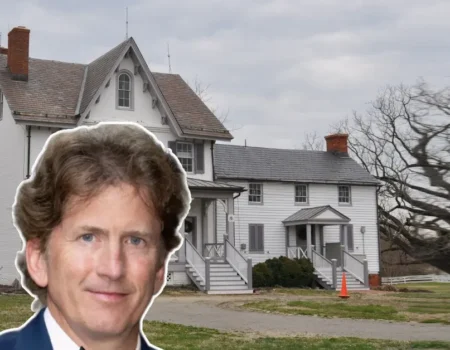 Todd Howard House, a historic white farmhouse with steep gable roof and brick chimneys, surrounded by trees and open sky.