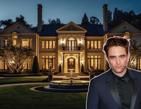 Robert Pattinson standing in front of a Spanish Colonial Revival home, symbolizing his Hollywood Hills real estate portfolio.