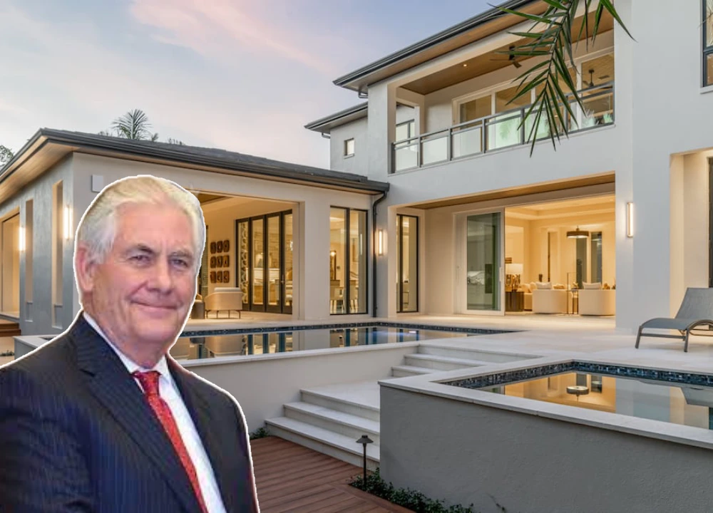 Portrait of Rex Tillerson in a formal suit with luxury homes in the background.