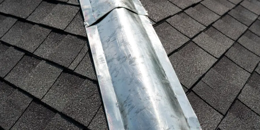Zinc strip fitted along the ridge of a clean shingle roof to prevent moss