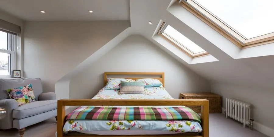loft conversion ideas: cozy loft bedroom with bed under the ridge and eaves storage