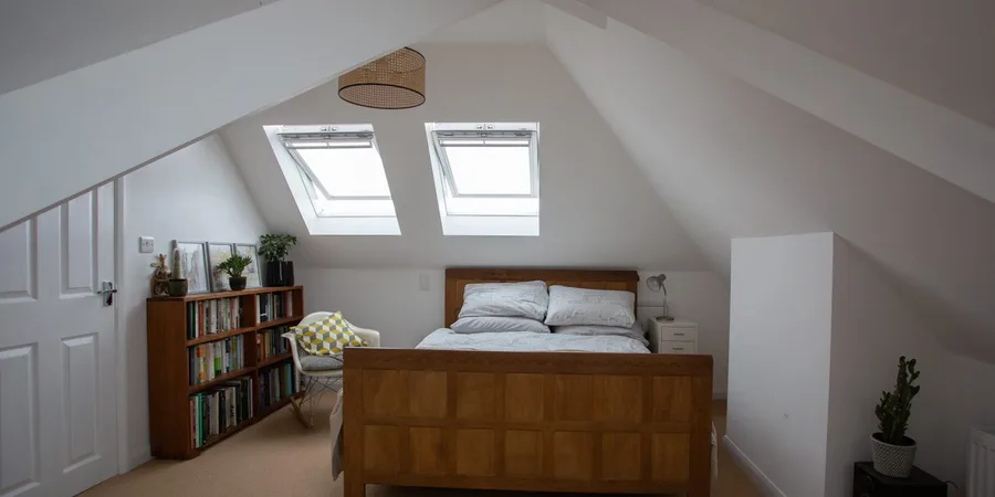loft conversion ideas: bright loft bedroom with skylights and sloped ceilings